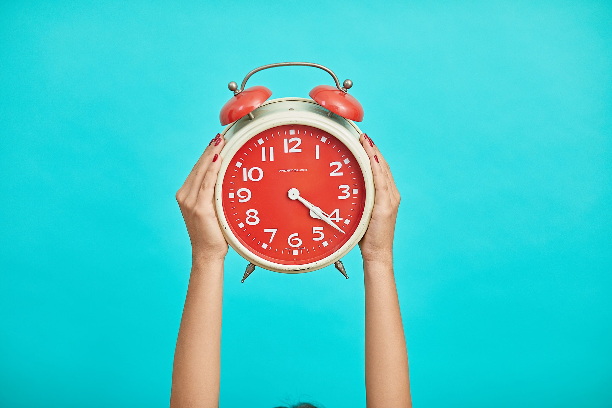 hands holding up red clock